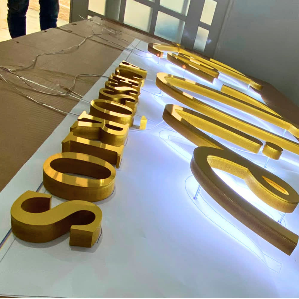 Letras douradas em produção na oficina